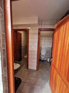 a bathroom with a toilet and a door and a doorway at Camping & Glamping Čenda in Železniki