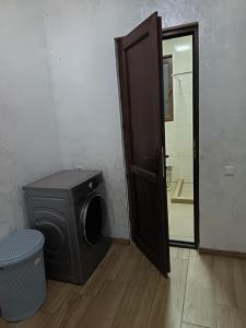 a door to a bathroom with a washing machine at Sunny Garden House in Ch'aisubani