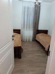 a room with two beds and an open door at Sunny Garden House in Ch'aisubani
