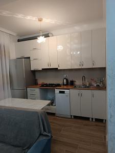 a small kitchen with white cabinets and a sink at Sunny Garden House in Ch'aisubani