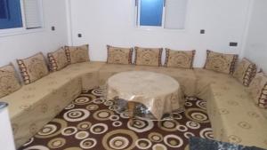 a couch with a table in the corner of a room at Tamawanza in Aourir