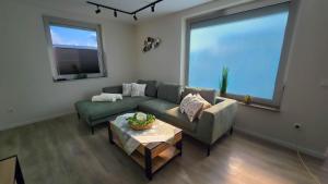 a living room with a couch and a table at Ferienhaus Hafenperle in Dornumersiel