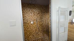 a bathroom with a shower with a tiled wall at Ferienhaus Hafenperle in Dornumersiel