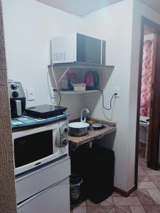 a small kitchen with a stove and a sink at Garcia Suite 2 in Blumenau