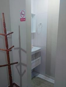 a bathroom with a sink and a no smoking sign at Garcia Suite 2 in Blumenau
