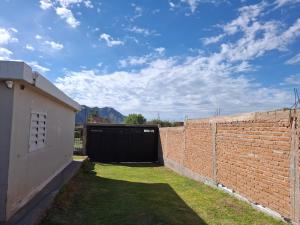 a garage with a brick wall and a gate at Casa en La Punta in La Punta