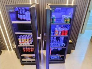 a refrigerator filled with bottles of water and soda at Pousada Terra do Sol in Itapema