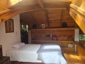 a bedroom with a bed in a room with wooden ceilings at Cabaña Baño de bosque in Coscotitlán