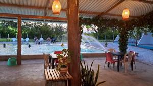 a patio with a table and chairs in front of a pool at Finca campestre Wakanda in Doradal