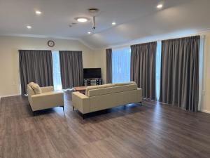 a living room with two couches and a table at Anglesea Motel and Conference Centre in Hamilton