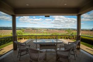 a patio with a table and chairs on a balcony at Thicker Than Water Vineyard - 4 Bedroom Pool in McLaren Vale