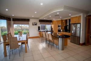 a kitchen with a table and chairs and a refrigerator at Thicker Than Water Vineyard - 4 Bedroom Pool in McLaren Vale