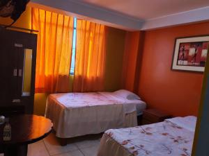 a hotel room with two beds and a window at Hostal paris in Nazca