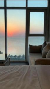 a bedroom with a bed and a view of the ocean at Bue waves in Kuwait