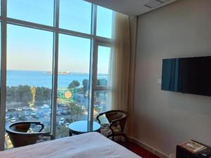 a room with a bed and a large window at Bue waves in Kuwait