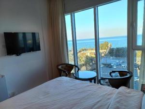a bedroom with a bed and a view of the ocean at Bue waves in Kuwait