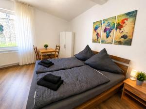 a bedroom with a large bed and a table at Zum Rheinberg Rhein Studio in Braubach