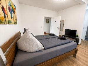 a large bed in a room with a television at Zum Rheinberg Rhein Studio in Braubach