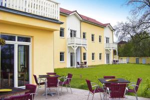 a patio with tables and chairs in front of a building at Appartement im Seedomizil Kummerow in Kummerow