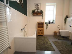 a bathroom with a tub and a toilet at Appartement im Seedomizil Kummerow in Kummerow +29 photos