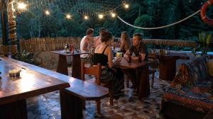 a group of people sitting at tables in a restaurant at Hostal Portobelo in Portobelo
