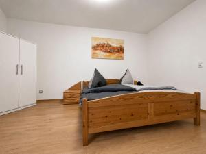 a bedroom with a wooden bed and a painting on the wall at Zum Rheinberg City Studio in Braubach
