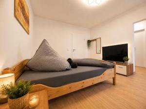 a bedroom with a wooden bed with a flat screen tv at Zum Rheinberg City Studio in Braubach