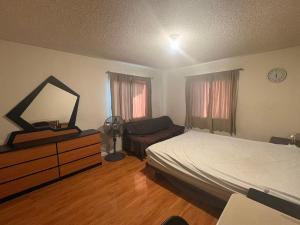 a bedroom with a bed and a dresser and a mirror at Palm Cabin in San Gabriel
