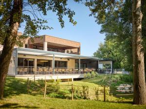a large building with a fence and trees at Novotel Valence Sud in Valence
