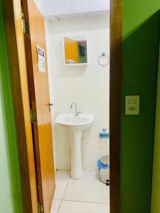 a bathroom with a sink and a toilet at quarto aconchegou 1 in Divinópolis +3 photos
