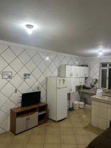 a kitchen with a refrigerator and white cabinets at quarto aconchegou 1 in Divinópolis