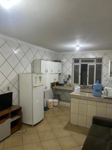 a kitchen with a white refrigerator and a sink at quarto aconchegou 1 in Divinópolis