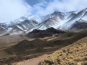 a snow covered mountain range with a dirt road at Cabaña Los Cardones in Campanas