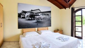 a bedroom with a bed and a picture of a truck at HOTEL VELHA CORTE VW-AUDI Sjp in São José dos Pinhais +18 photos