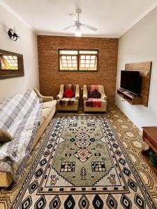 a living room with a couch and a rug at Recanto Dom José in Peruíbe