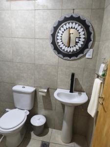 a bathroom with a toilet and a sink and a mirror at Urku Runa in Humahuaca