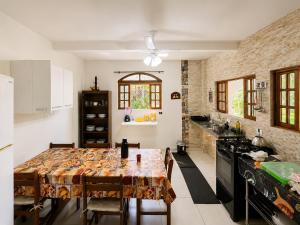 a kitchen with a table with chairs and a stove at Recanto Dom José in Peruíbe