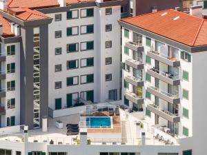 an aerial view of a building with a swimming pool at Atlantic Dutchman Heated Pool & Parking in Caniço
