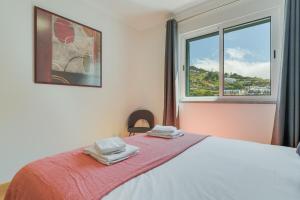a bedroom with a bed with two towels on it at Atlantic Dutchman Heated Pool & Parking in Caniço
