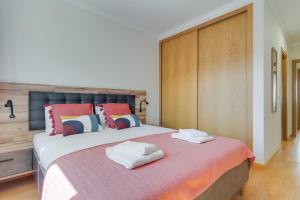 a bedroom with a large bed with towels on it at Atlantic Dutchman Heated Pool & Parking in Caniço