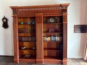 a wooden book shelf with a clock on it at Casa Lavinia in São Luís