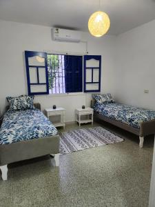 a living room with two beds and a window at Villa SiJoBa in Raʼs al Jabal