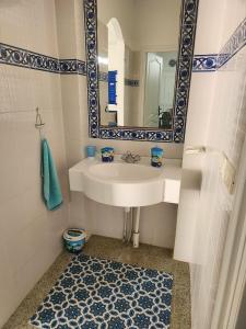 a bathroom with a sink and a mirror and a rug at Villa SiJoBa in Raʼs al Jabal +32 photos