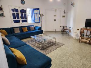 a living room with a blue couch and a table at Villa SiJoBa in Raʼs al Jabal