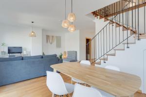 a living room with a wooden table and white chairs at Alta Do Garajau I 5ºw in Caniço