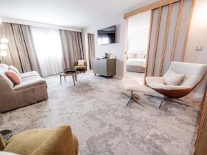 a living room with a couch and chairs at Mercure Bordeaux Lac in Bordeaux