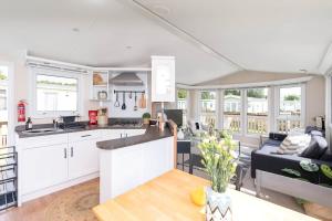 a kitchen and living room with white cabinets at The Chester-2 bed Static Caravan in Oxnam