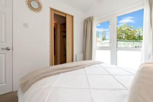 a white bedroom with a bed and a window at The Chester-2 bed Static Caravan in Oxnam