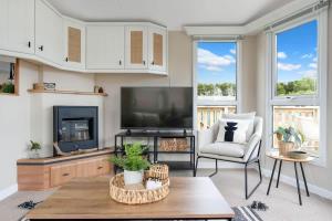 a living room with a flat screen tv and a table at The Chester-2 bed Static Caravan in Oxnam