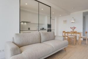 a living room with a couch and a table at Pool Retreat For Families & Romantic Escapes in Câmara de Lobos